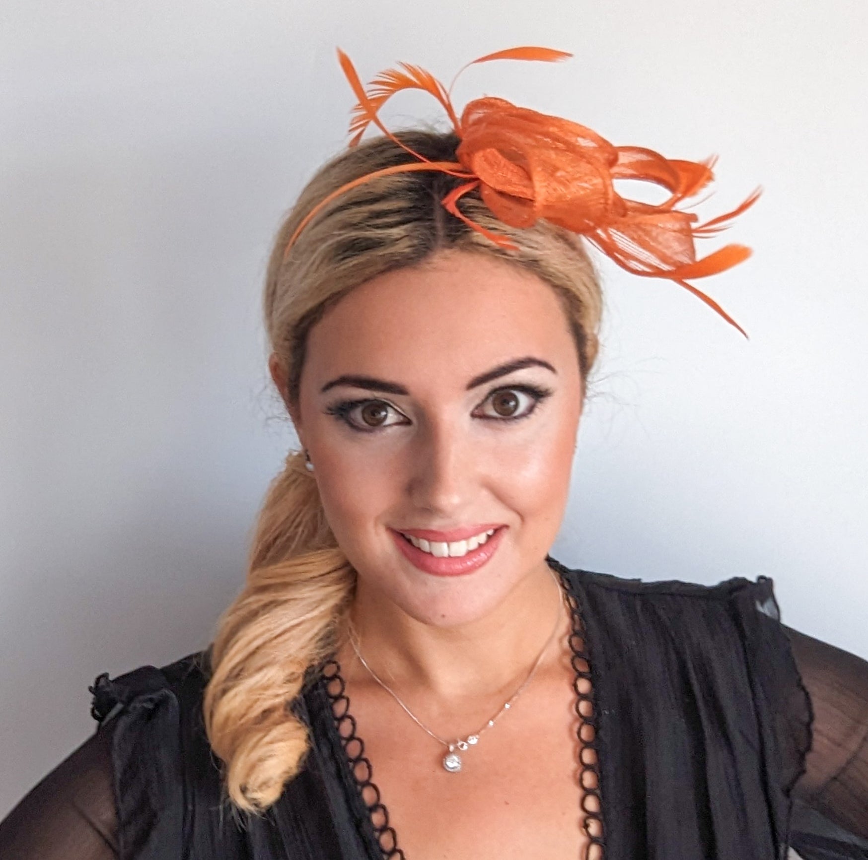 Orange feather fascinator hat