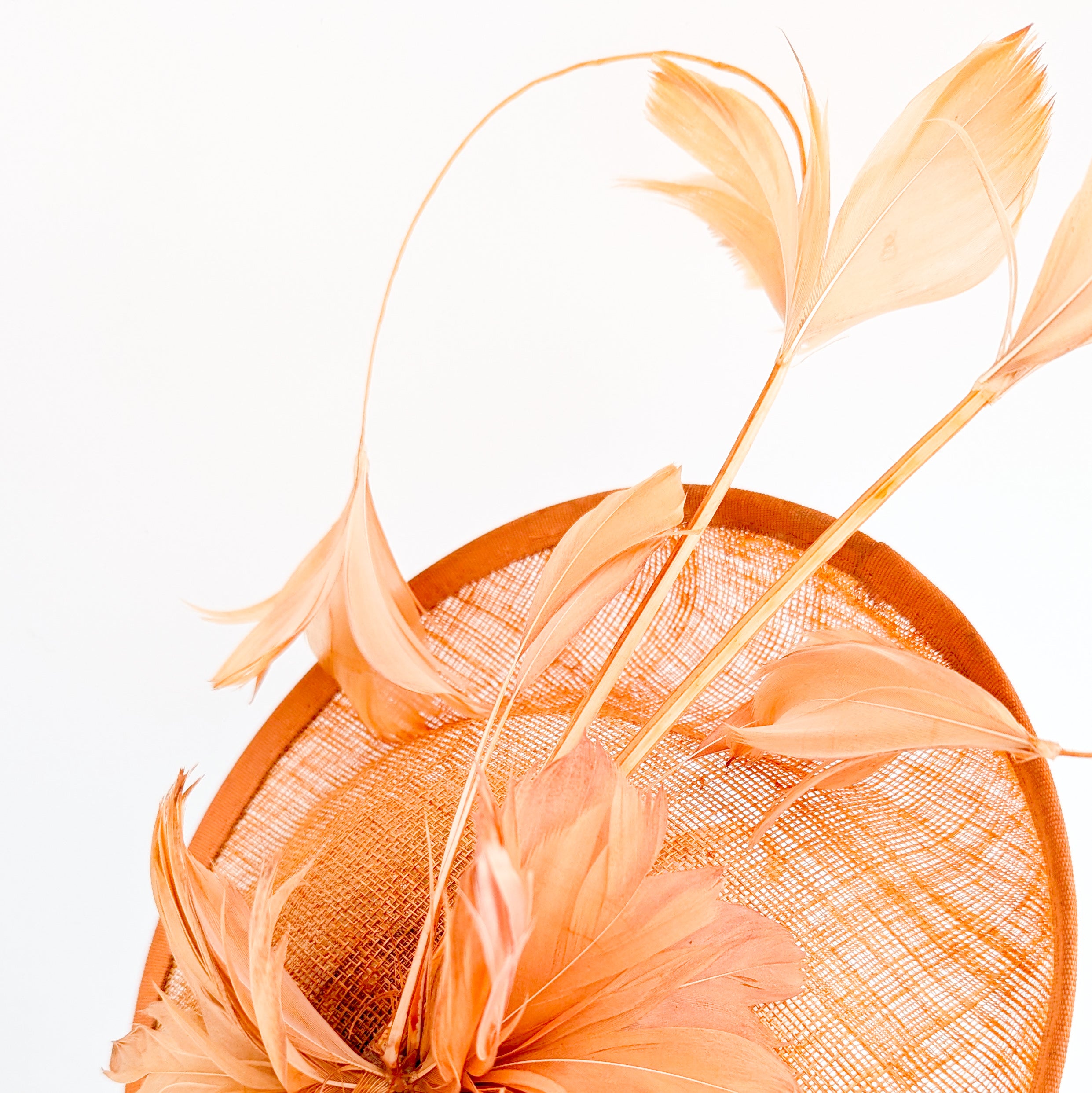 Dusty terracotta orange feather disc fascinator hat