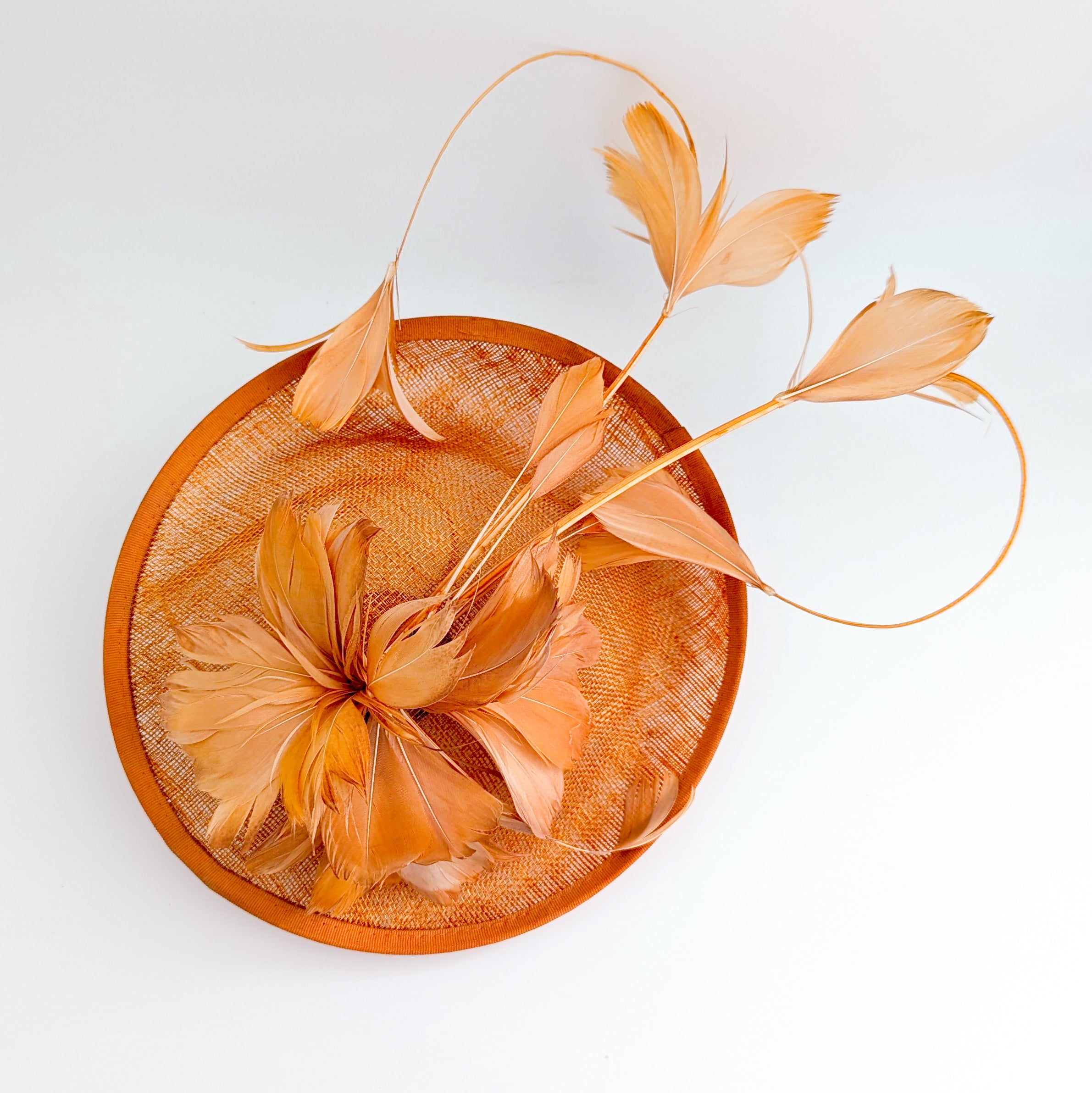 Dusty terracotta orange feather disc fascinator hat