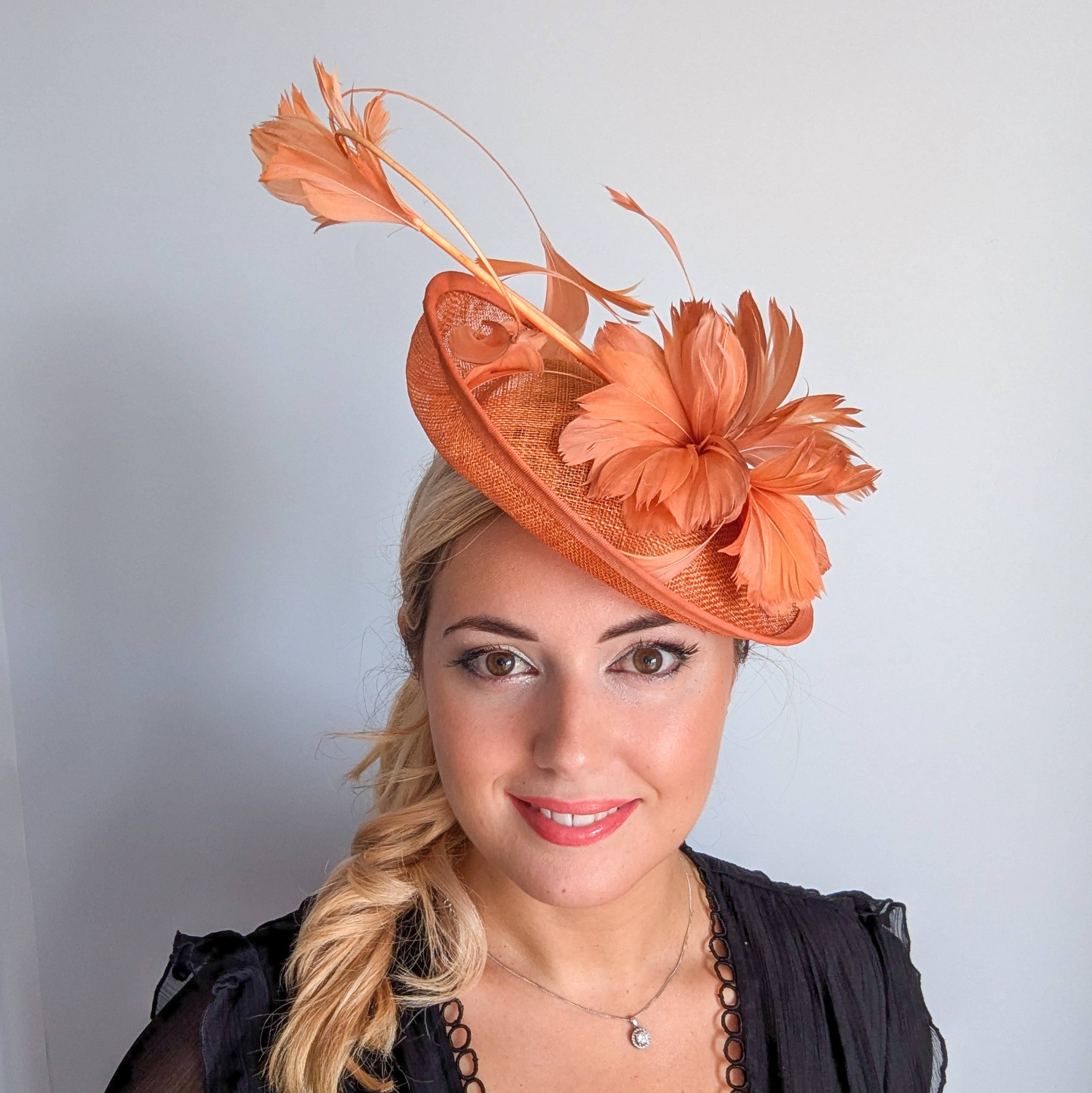 Dusty terracotta orange feather disc fascinator hat