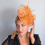 Tangerine orange flower feather disc fascinator hat